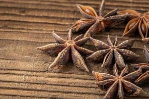 Dried star anise spice on vintage wooden board photo