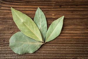 Dried bay leaves on dark rustic wooden background. photo
