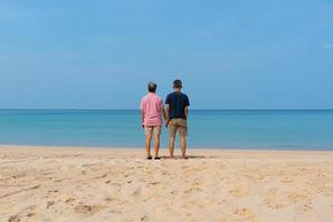 A couple of senior asian adults standing on the beach photo