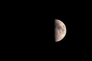 a lunar eclipse the moon is half visible,the background is black photo