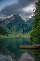 un montaña lago con barcos en un hermosa montaña, en nublado clima foto