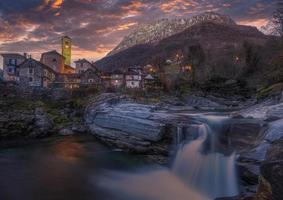 puesta de sol en un pequeño pueblo con un cascada foto