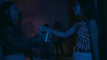 ein Paar von asiatisch Jugendliche im Exzenter Kleider reden zu jeder andere während hängend aus beim ein Nachtclub video