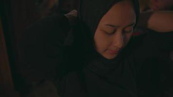 uma muçulmano mulher é vestindo uma Preto lenço de cabeça dentro frente do uma ampla espelho para pegue pronto video