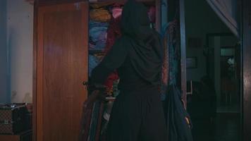 een moslim vrouw was schoonmaak omhoog vuil kleren dat waren verspreide Aan de bed video