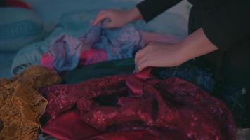 ein Muslim Frau gefunden ihr Liebling Kleider auf ein Stapel von schmutzig Kleider im ein Zimmer video