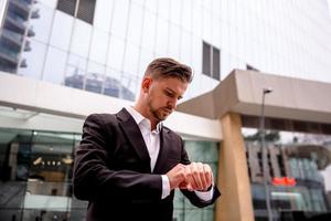 retrato de un joven empresario mirando a su reloj foto