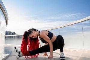 aptitud física, ejercicio y un mujer extensión a gimnasio durante calentar arriba rutina de ejercicio y formación para salud y bienestar. Deportes hembra o atleta en suelo a tramo piernas a ser flexible, equilibrar y sano foto