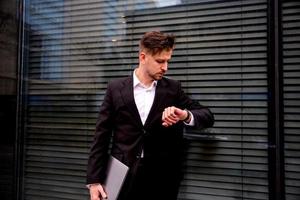 Portrait of a young businessman in a business center with a laptop in his hands photo