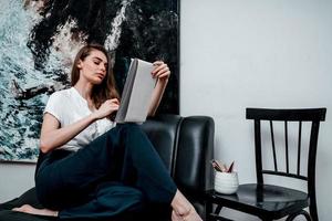 Young artist draws with pencils a sketch for a picture in a cozy workshop photo