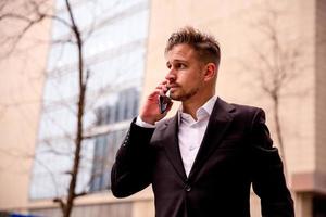 Portrait of a young businessman in a business center talking on the phone photo