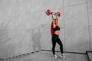 Fitness, body builder and woman with barbell training, workout or challenge exercise for muscle power, energy and goal. Strong, power and sports person with gym motivation and bodybuilder challenge photo