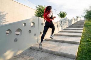 Fit young woman jumping and running photo