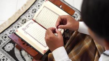 persona Orando en un Corán libro video