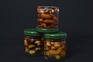 Glass jars with nuts in honey. Delicious sweets. Nuts in honey. Sweet nuts. photo