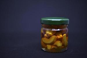 Glass jars with nuts in honey. Delicious sweets. Nuts in honey. Sweet nuts. photo