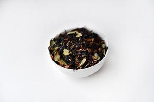 negro té con especias en un vaso taza en un blanco antecedentes. delicioso té. seco té. foto