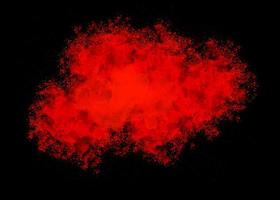Red color dust particle explosion cloud on black background.color powder splash photo