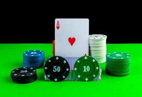 Poker game, deck of cards, ace card and stacks of chips on the table. photo