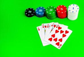 Poker chips in stacks and a royal flush on a green table. photo