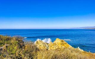 Beautiful rocks cliffs surfer waves at beach Puerto Escondido Mexico. photo