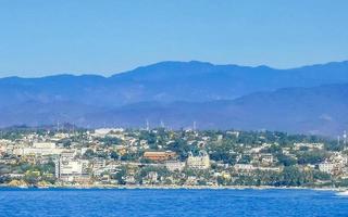 Sun beach cliffs rocks waves palms mountains Puerto Escondido Mexico. photo