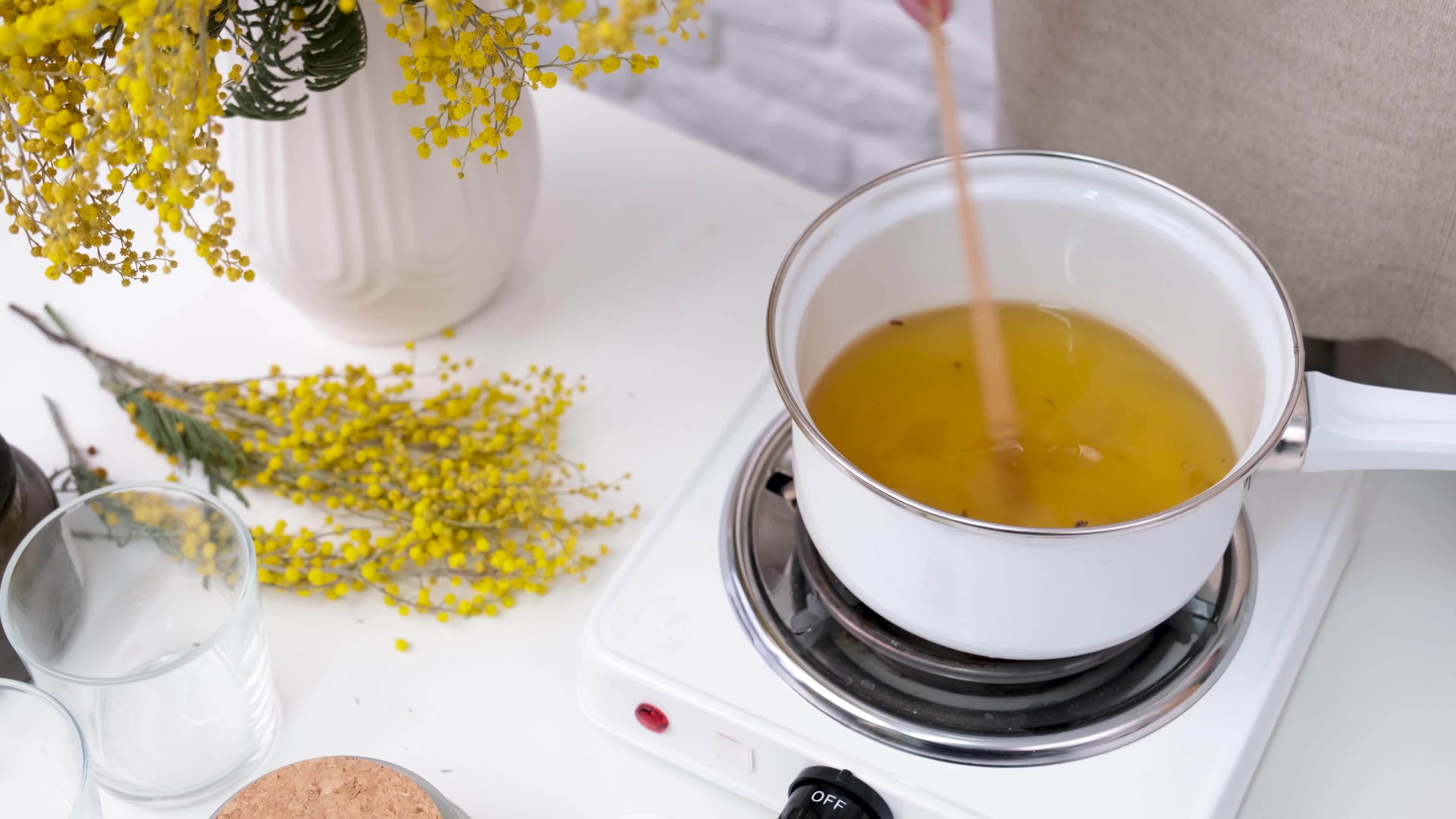 woman making candles, melting soy wax in the pot 20877745 Stock Video at Vecteezy