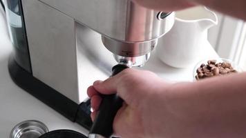 masculino manos participación portafiltro y haciendo Fresco aromático café a hogar utilizando un moderno café fabricante video