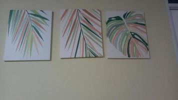 lona pintura representando palma hojas en un blanco pared foto