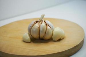 Garlic and garlic cloves on a wooden chopping board. Garlic product photo in photo studio. landscape image.