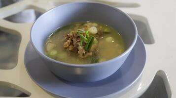 Oxtail soup is a soup made with beef tails served in a table photo