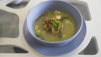 Oxtail soup is a soup made with beef tails served in a table photo