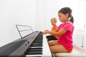 hermano y hermana jugando piano foto
