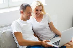 Young Couple Using Laptop On Desk At Home and think photo