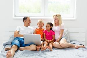 Beautiful smiling multiethic family in front of the laptop video call with distant parents at home. photo