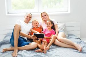 hermosa sonriente multiético familia en frente de el ordenador portátil vídeo llamada con distante padres a hogar. foto