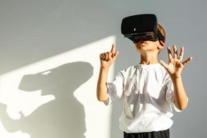 The boy wearing virtual reality goggles on the white background photo