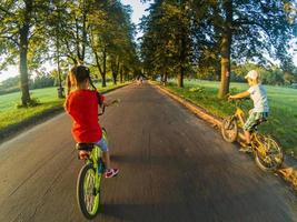 niños en bicicletas en el parque cerca escuela. foto