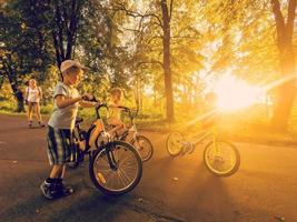 bicicleta familia de viaje en el la carretera a puesta de sol foto