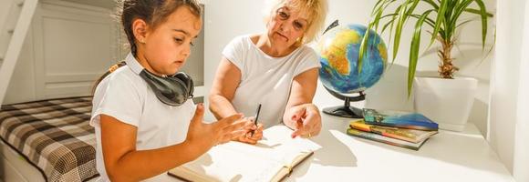 Portrait of grandmother and granddaughter doing homework photo