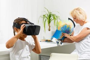 girl explains to an elderly woman how to use virtual reality glasses. The older generation and new technologies. photo