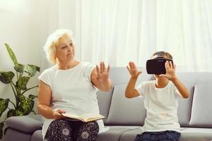 mayor mujer utilizando virtual realidad lentes con su nieta foto