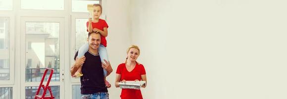 Smiling young loving family posing in their new house, relocation and home improvement concept photo