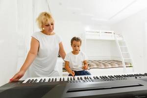 grandmother and granddaughter play the piano photo