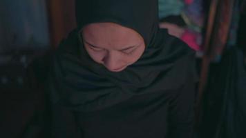 confused expression of a Muslim woman who is looking for her favorite clothes she has on the bed video