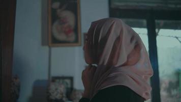 een moslim vrouw vervelend een room sluier in voorkant van een bedenken spiegel heel voorzichtig video
