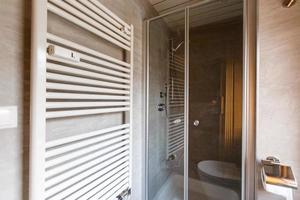 Modern spacious bathroom with bright tiles with toilet and sink. Side view photo