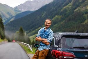 un hombre cerca el coche en el montañas foto