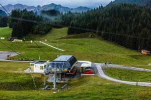 Ski lift in summer. Cable car. View from the mountain. Beautiful landscape. Ski track in summer. Funicular. Mountainous terrain. photo