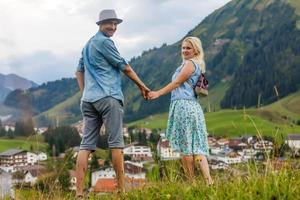 joven amantes relajante en fiesta en hermosa panorama con montañas Baviera Alemania. Pareja en amor relajante en primavera foto